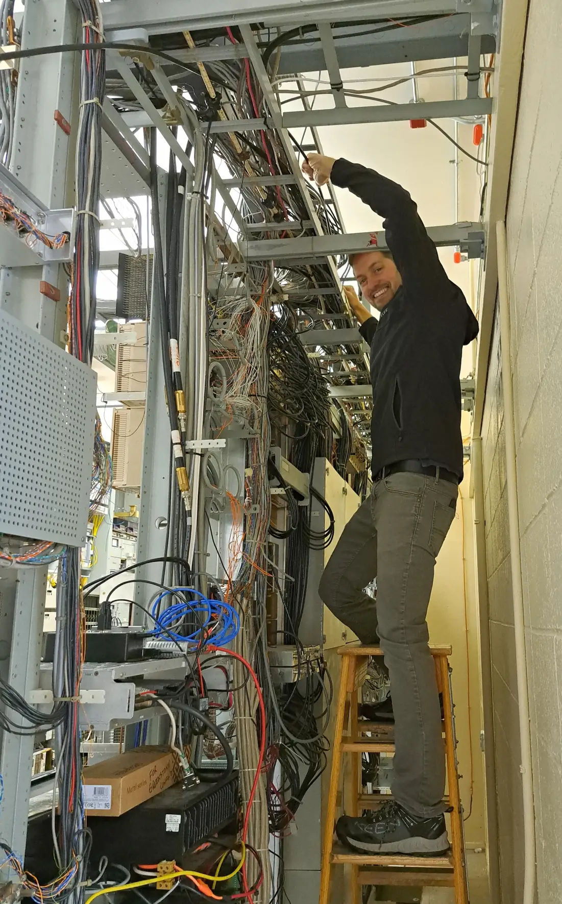 Low-voltage wiring installation Kansas City - technician pulling cable through wall